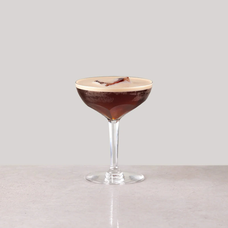 Niets Frappé cocktail in a glass, topped with cream and garnished, showcasing its rich espresso color.
