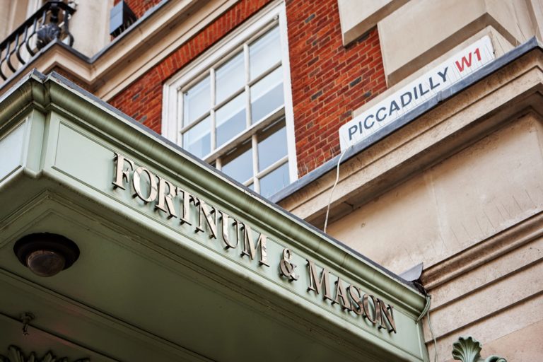 Exterior of Fortnum & Mason store in Piccadilly, highlighting the entrance and featuring Fortnum & Mason non-alcoholic beverages signage.