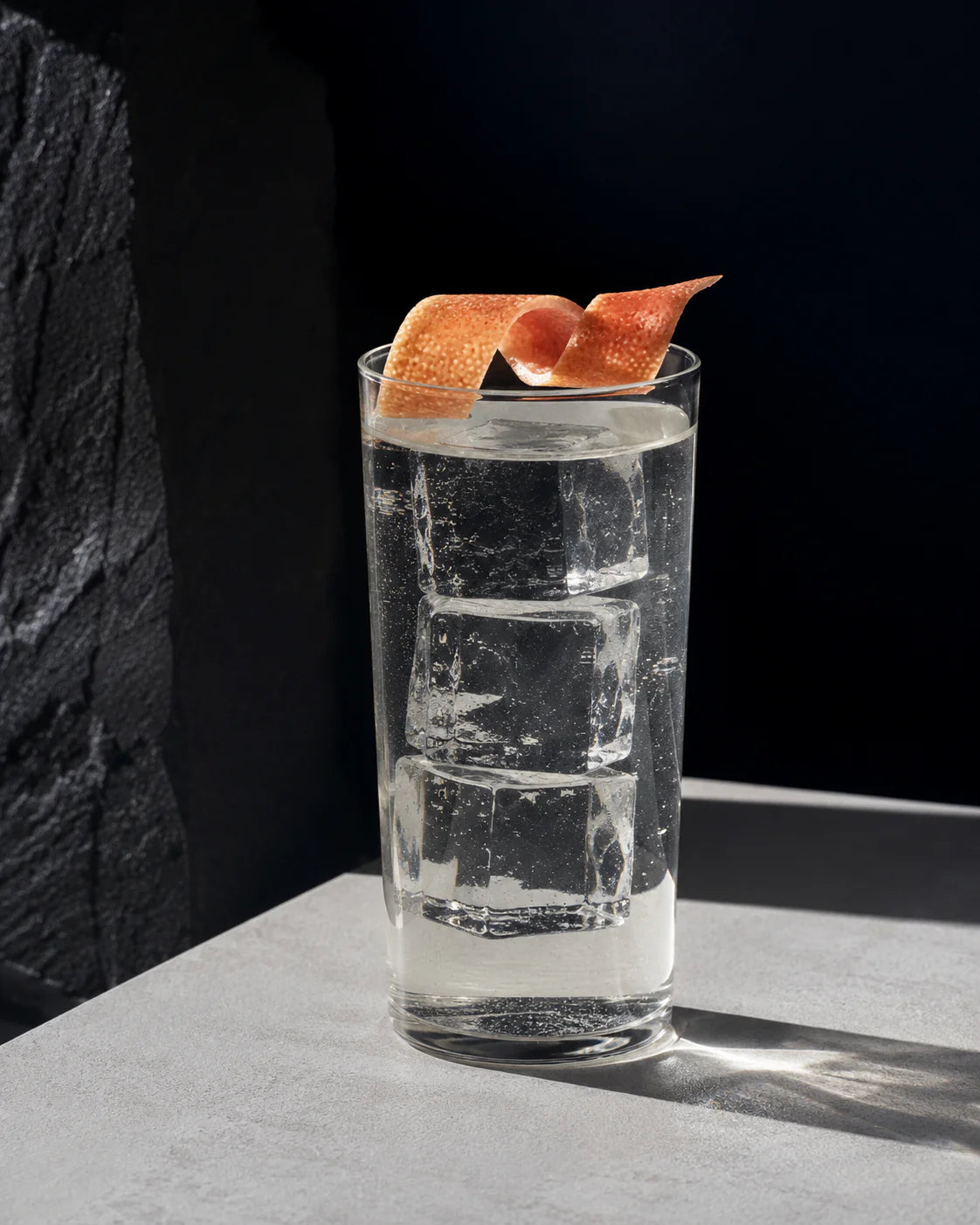 A refreshing Dry & Tonic drink served in a tall glass with ice and a twist of citrus peel atop.