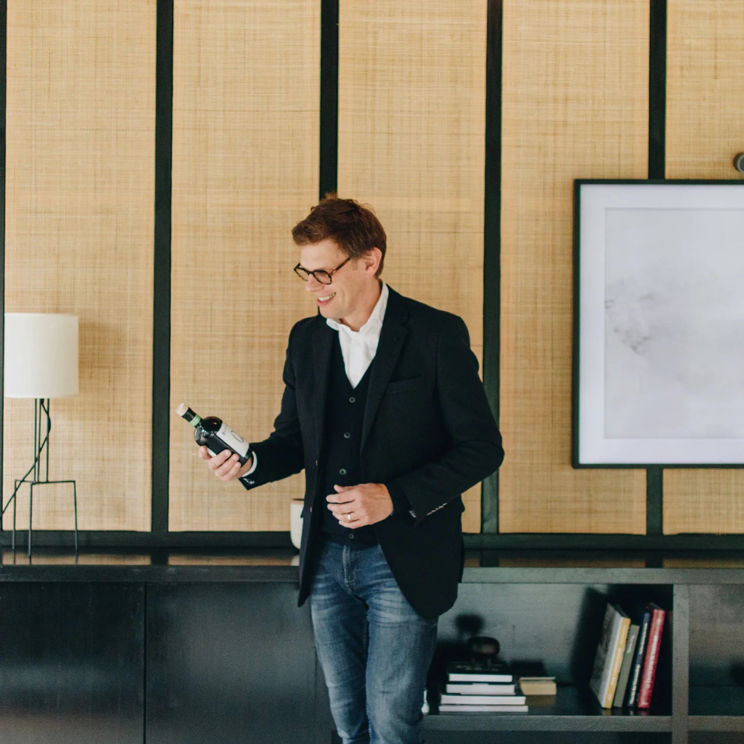 Niets supported by Finance&Invest.Brussels: a man holding a bottle in a stylish interior.