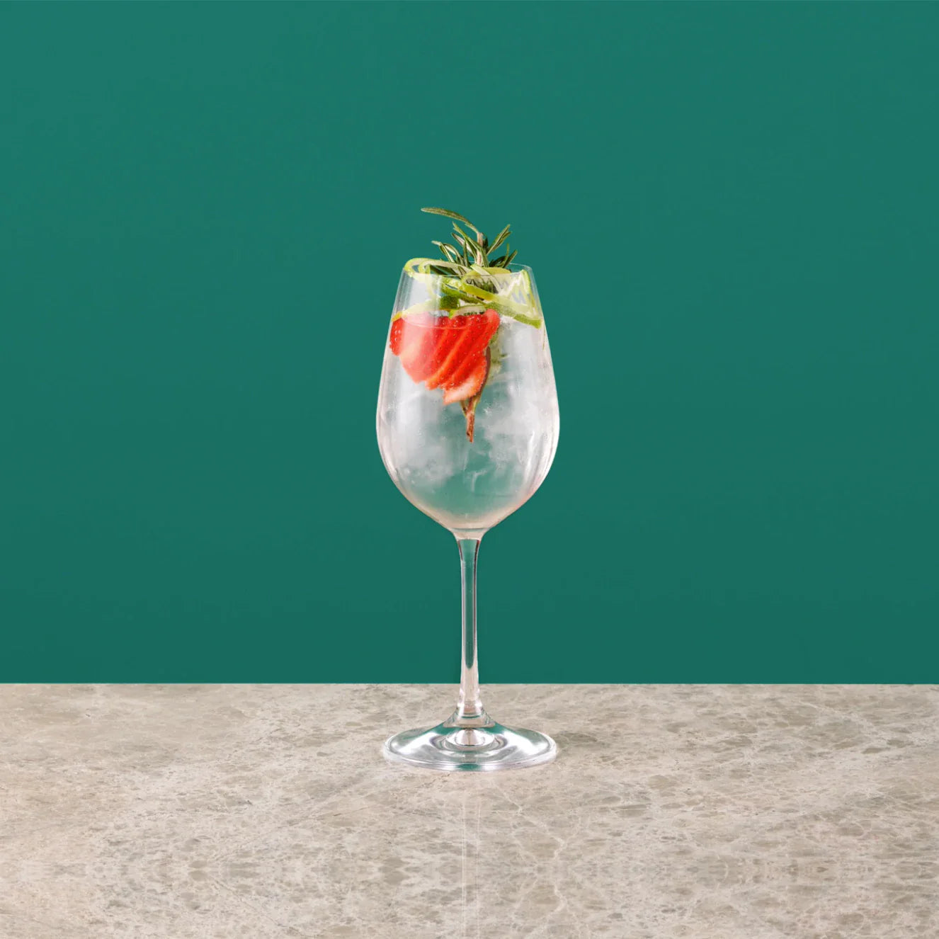 Strawberry Royal cocktail with sliced strawberries and fresh mint leaves in a glass.
