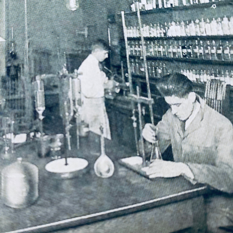 Historical black and white photo of scientists in a laboratory setting.